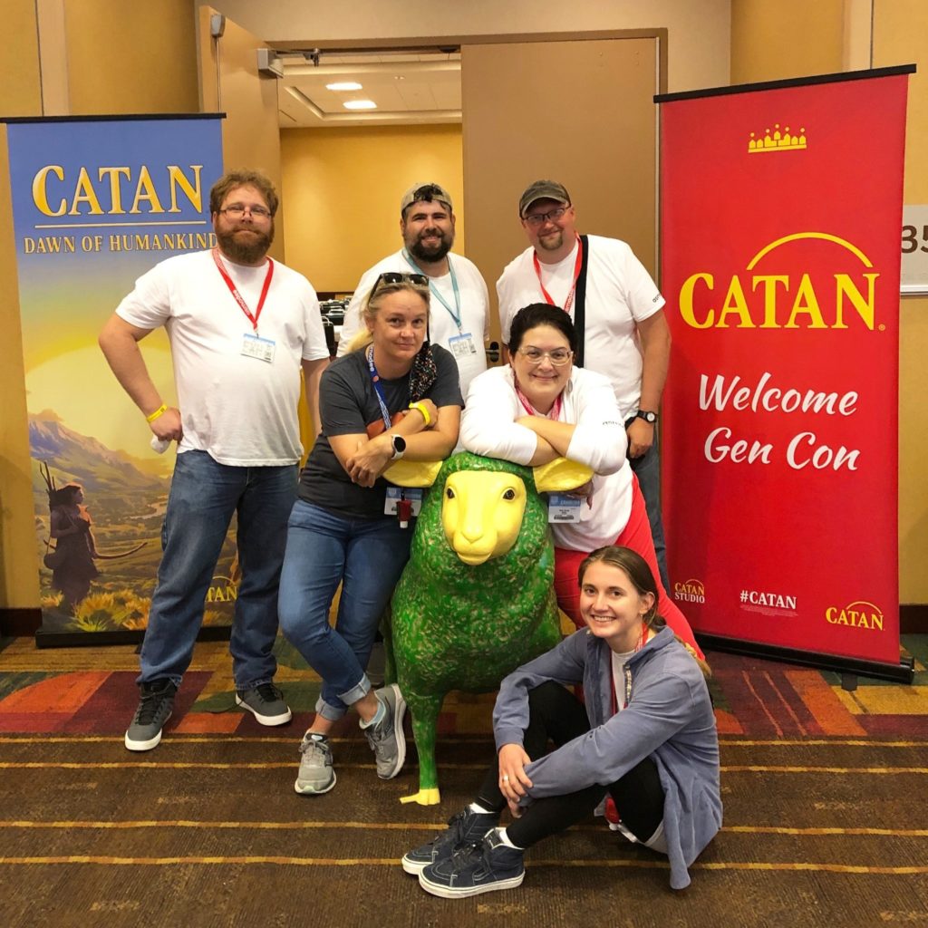Contractors at Gen Con 2022 posing with green and yellow sheep